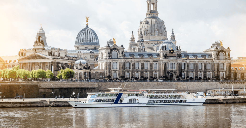 River Cruise Webinar Featured Image. River cruise boat on the river, with a beautiful building in the background.